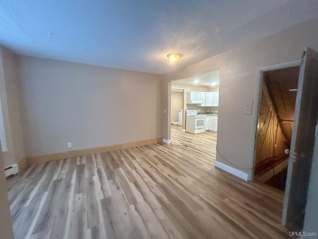 unfurnished living room featuring a textured ceiling and light wood-type flooring