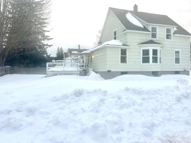 snow covered property featuring a wooden deck