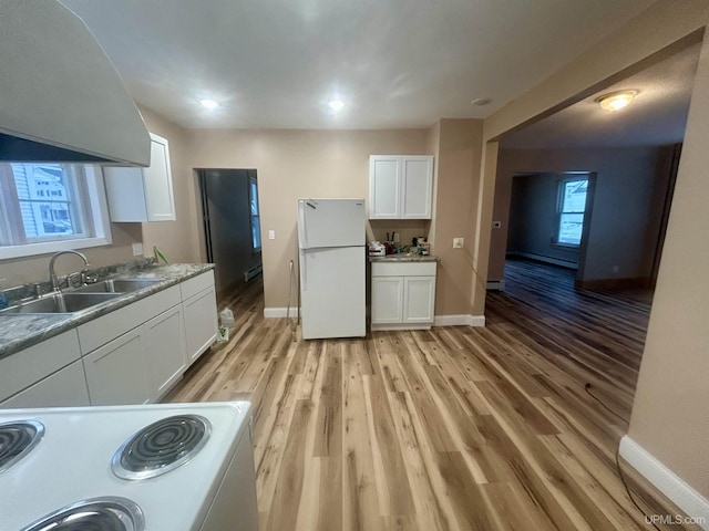 301 E Chocolay St, Munising, MI 49862 - kitchen featuring freestanding refrigerator, stove, white cabinets, and light wood-type flooring