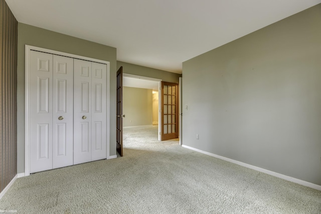 unfurnished bedroom featuring a closet and light colored carpet