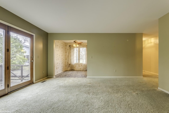 spare room with ceiling fan and light carpet