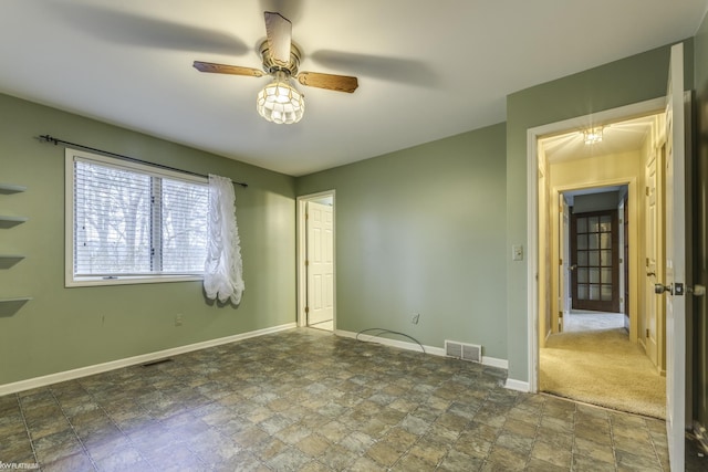 unfurnished bedroom featuring ceiling fan and dark carpet