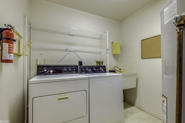 clothes washing area featuring independent washer and dryer and electric water heater