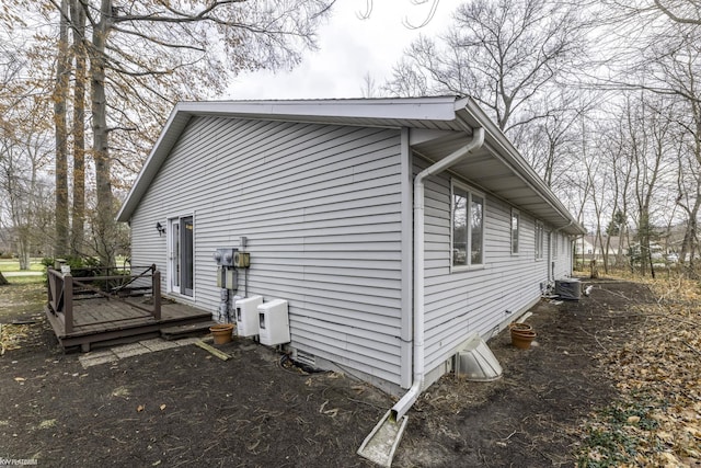 view of side of property with a deck and central air condition unit