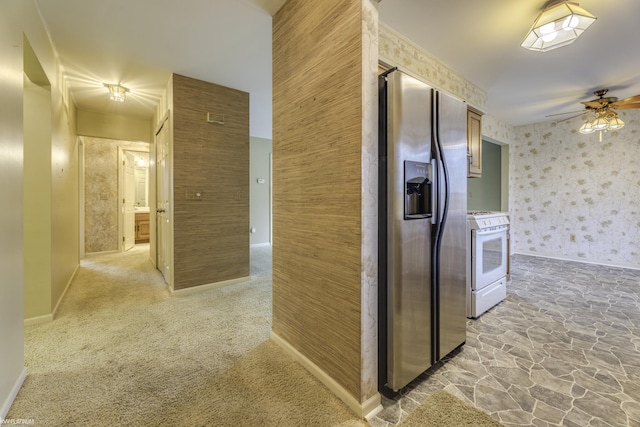 kitchen with ceiling fan, stainless steel fridge with ice dispenser, light carpet, and gas range gas stove