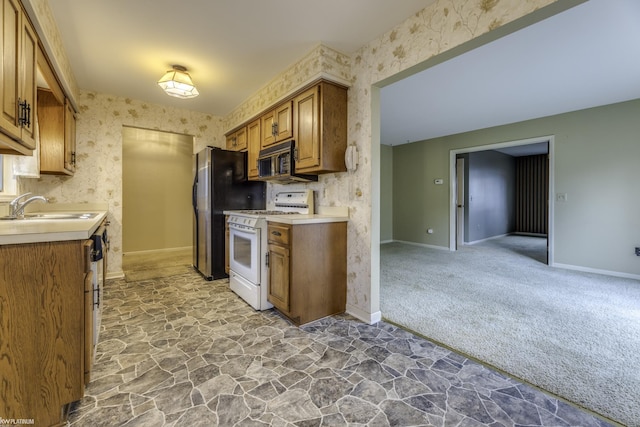 kitchen with carpet, stainless steel fridge, white range with gas cooktop, sink, and dishwasher