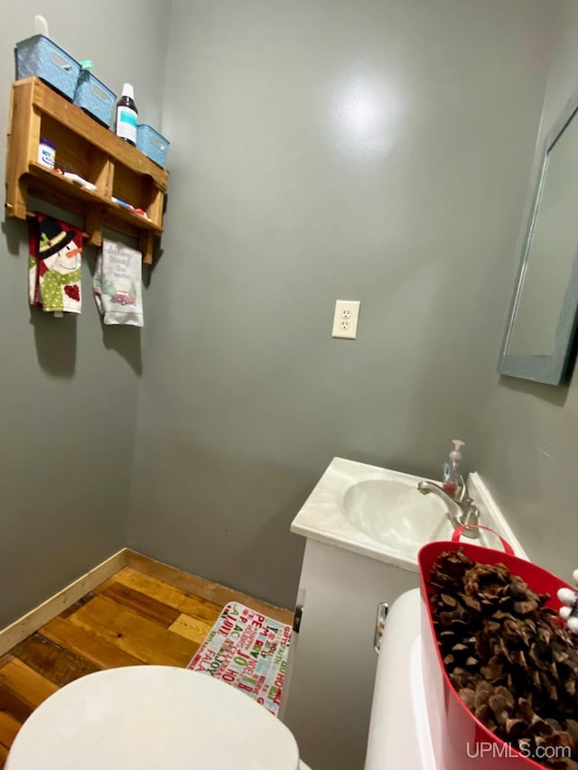 bathroom with hardwood / wood-style flooring, toilet, and vanity