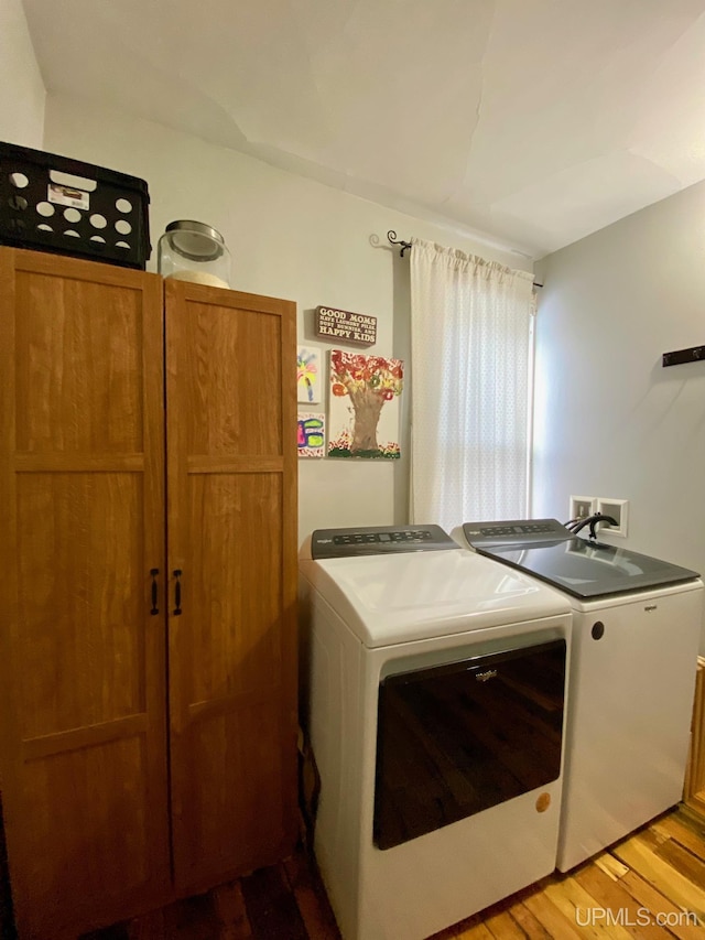 washroom with washing machine and dryer and light hardwood / wood-style floors