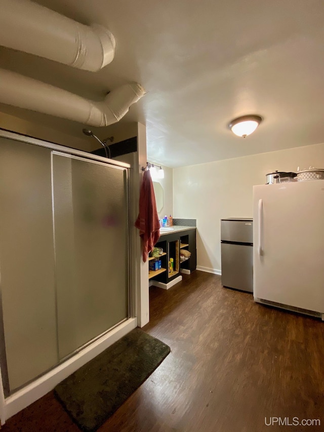 bathroom with an enclosed shower and wood-type flooring