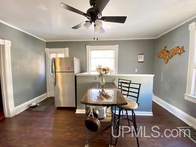 dining area featuring ceiling fan, dark hardwood / wood-style floors, and crown molding