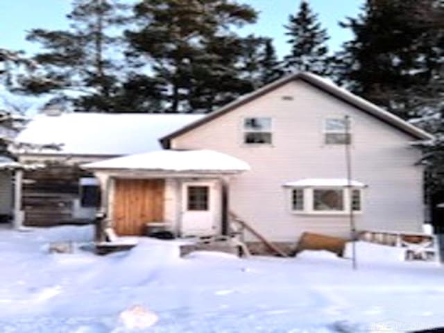 view of snow covered back of property