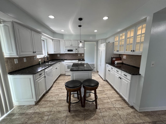 kitchen with white cabinetry, a center island, hanging light fixtures, tasteful backsplash, and white appliances