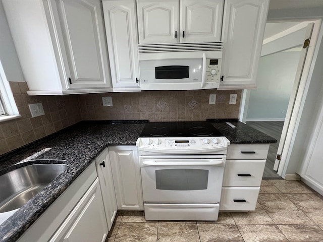 kitchen with white cabinets, white appliances, and dark stone countertops