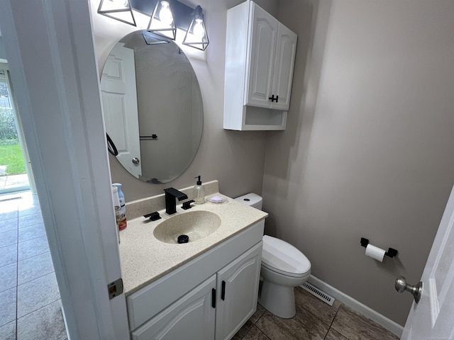 bathroom featuring tile patterned flooring, vanity, and toilet