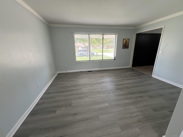 spare room with ornamental molding and dark wood-type flooring