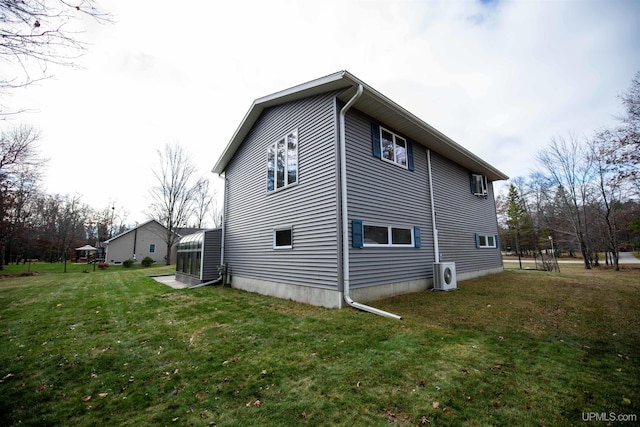 view of property exterior featuring a lawn, ac unit, and a sunroom