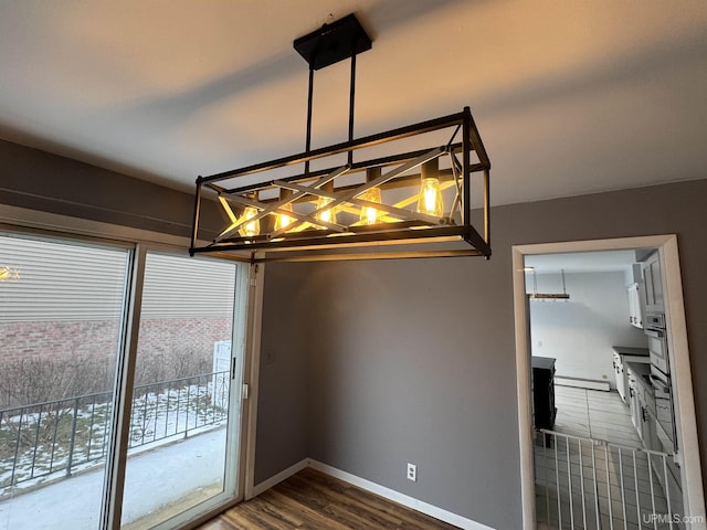 interior space featuring baseboard heating, a wealth of natural light, and wood-type flooring