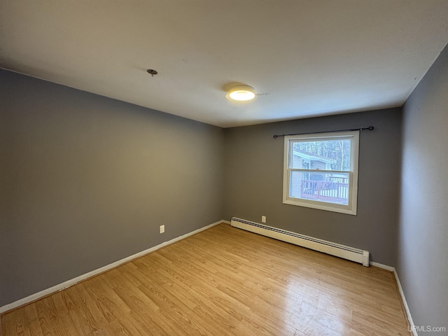 empty room featuring light hardwood / wood-style flooring and a baseboard radiator