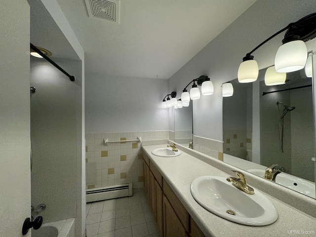 bathroom with tile patterned flooring, vanity, tile walls, and a baseboard heating unit