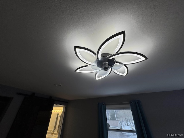 details featuring a barn door and ceiling fan