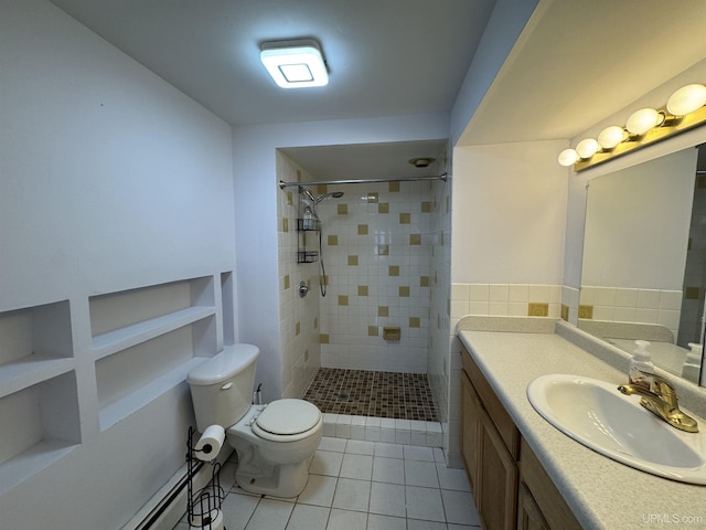 bathroom with tiled shower, vanity, tile patterned floors, and tile walls