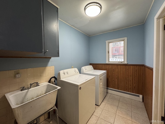 clothes washing area featuring cabinets, washer and clothes dryer, a baseboard heating unit, sink, and light tile patterned floors