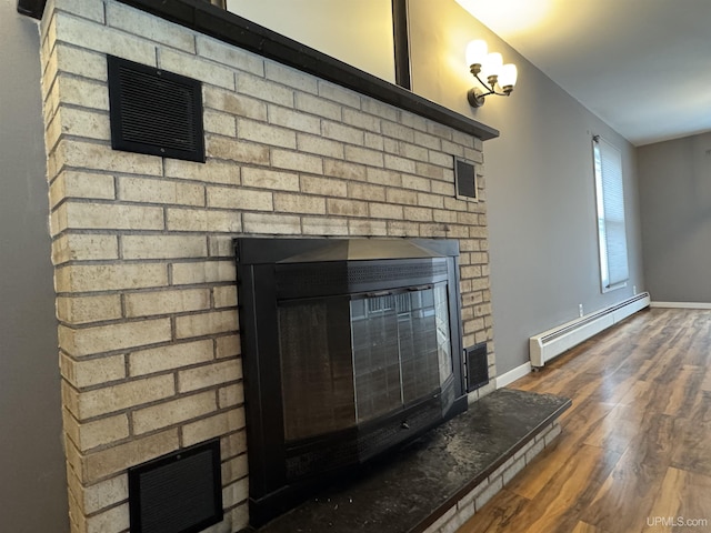 details featuring baseboard heating, a fireplace, and wood-type flooring