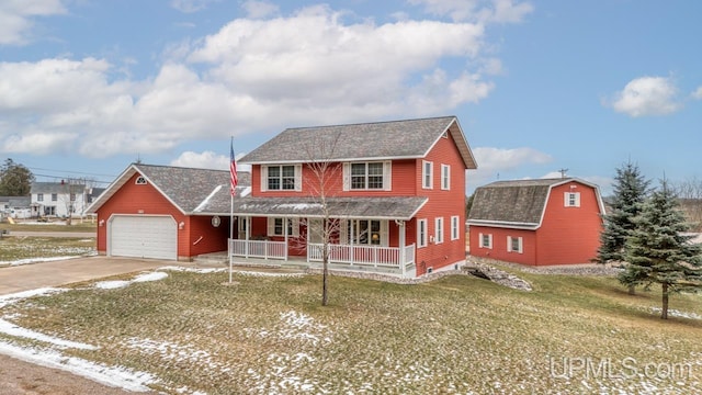 view of front of house with covered porch, a front yard, and a garage