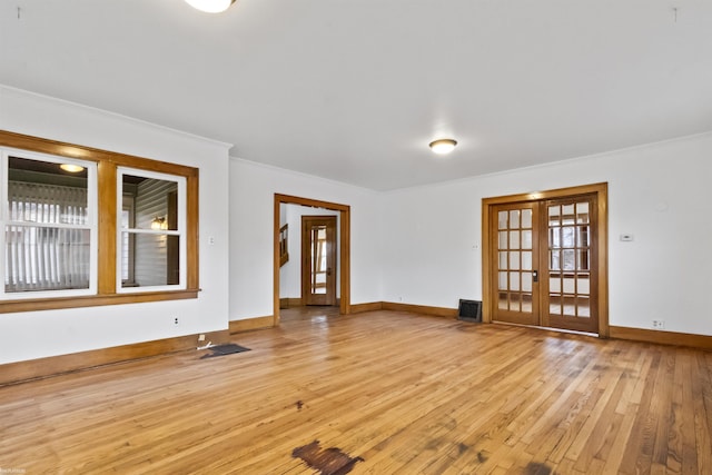 spare room featuring french doors, light hardwood / wood-style floors, and crown molding