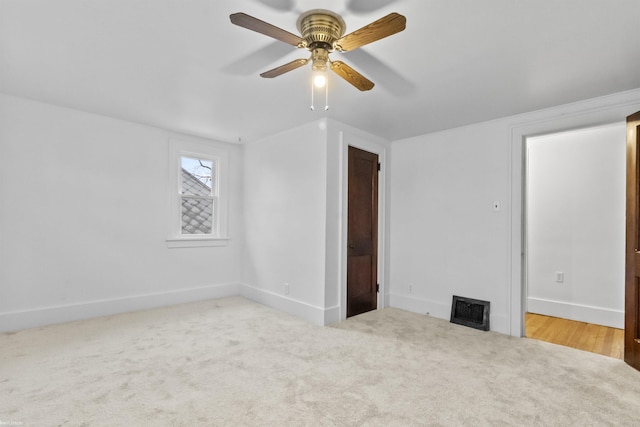 spare room featuring ceiling fan and light carpet