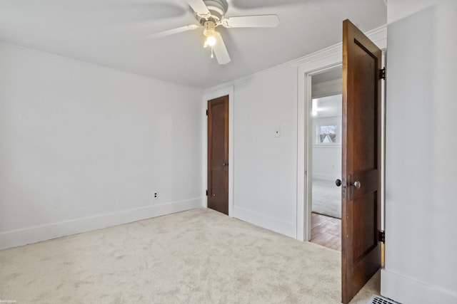 unfurnished bedroom with light carpet, ceiling fan, and crown molding