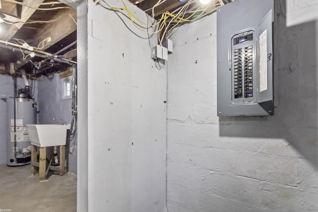 utility room featuring electric panel, gas water heater, and sink