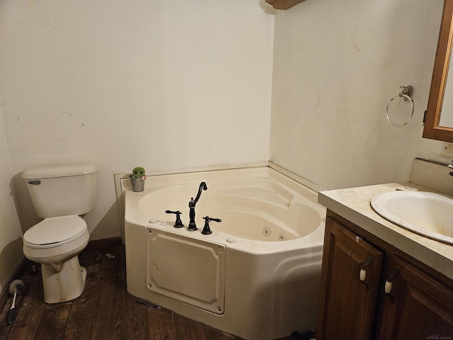 bathroom with toilet, a washtub, vanity, and hardwood / wood-style flooring