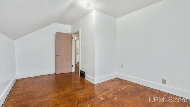 additional living space featuring vaulted ceiling and dark wood-type flooring