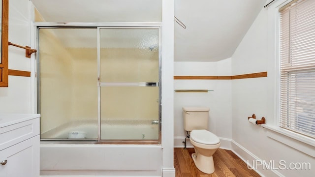 full bathroom featuring shower / bath combination with glass door, vanity, wood-type flooring, and toilet