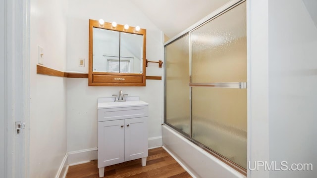 bathroom with shower / bath combination with glass door, vanity, lofted ceiling, and hardwood / wood-style flooring