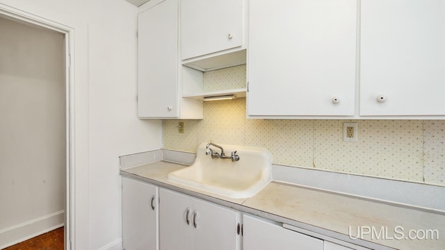 kitchen with white cabinets, decorative backsplash, dark wood-type flooring, and sink