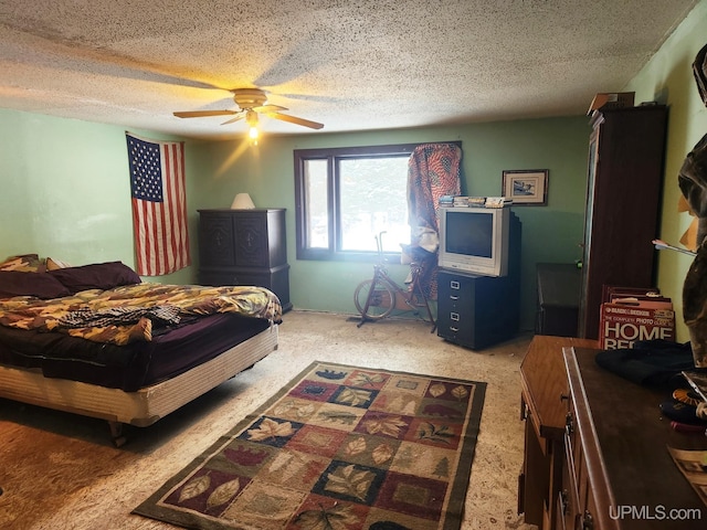 carpeted bedroom with ceiling fan and a textured ceiling