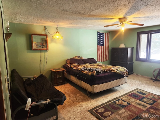 carpeted bedroom with ceiling fan and a textured ceiling