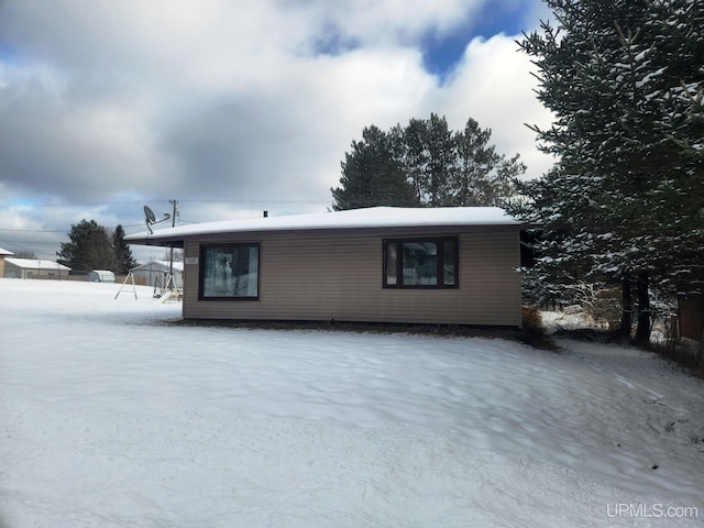 view of snow covered back of property