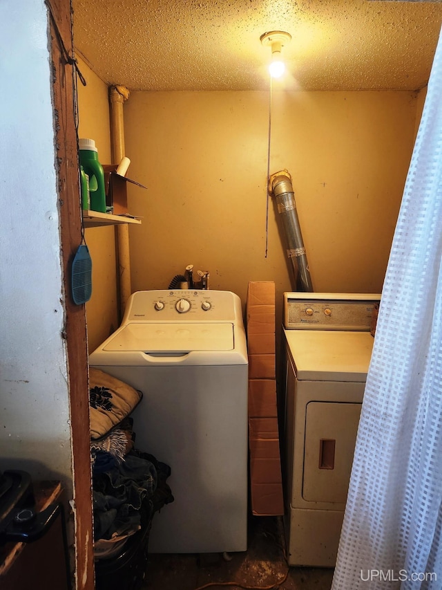 laundry room with washer and dryer and a textured ceiling