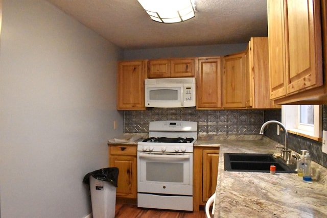 kitchen with dark hardwood / wood-style floors, decorative backsplash, white appliances, and sink