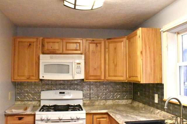 kitchen with white appliances, sink, and tasteful backsplash