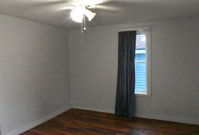 empty room with ceiling fan and dark hardwood / wood-style flooring