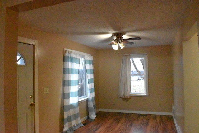 empty room featuring ceiling fan and dark wood-type flooring