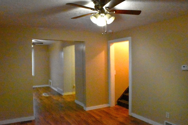 empty room with ceiling fan and dark wood-type flooring