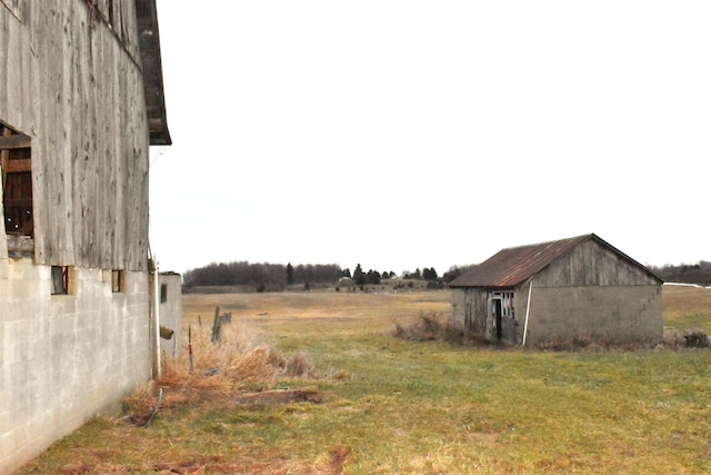 view of yard featuring a rural view and a storage unit