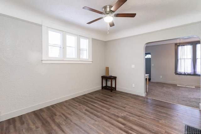 unfurnished room featuring dark hardwood / wood-style flooring, a wealth of natural light, and ceiling fan