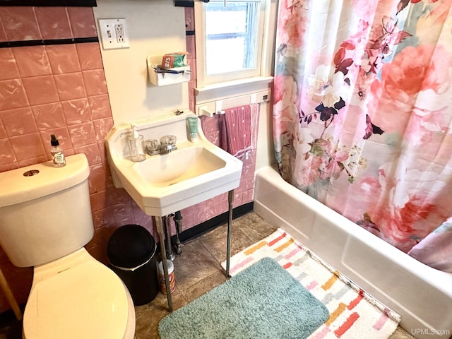 full bathroom featuring sink, toilet, shower / bathtub combination with curtain, and tile walls