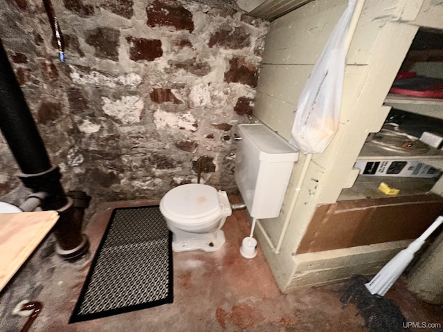 bathroom with concrete flooring and toilet